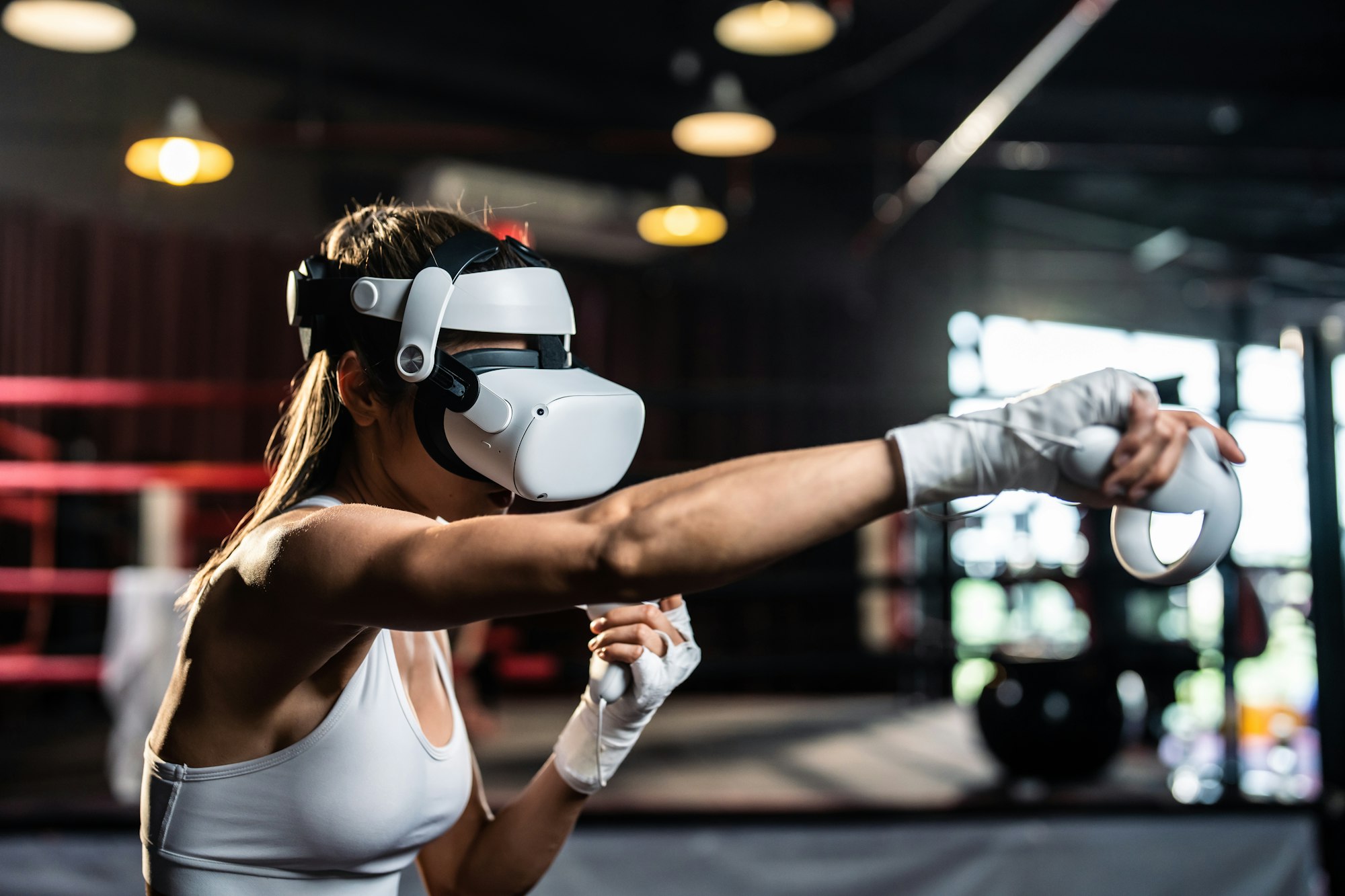 Asian sportswoman using innovative technology VR glasses for exercise.